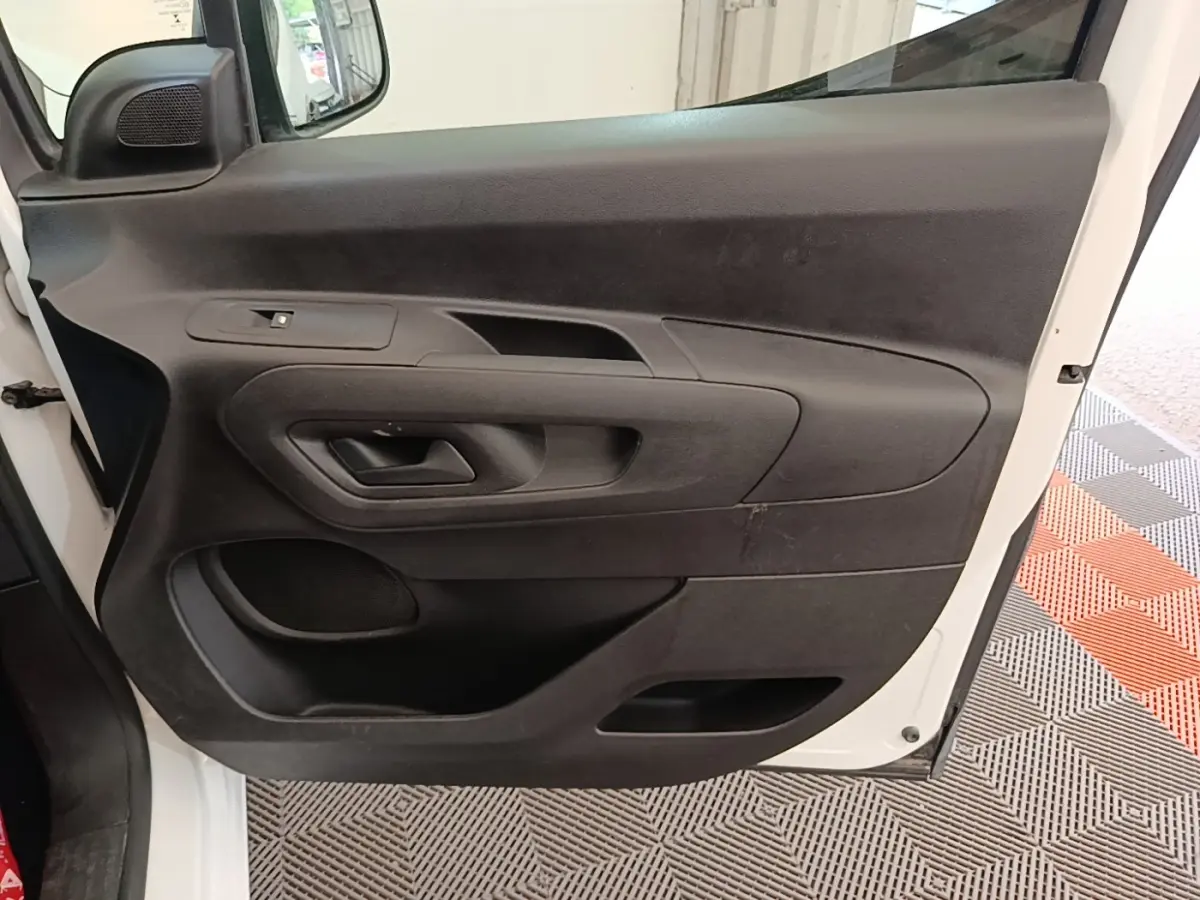 Vue intérieure de la porte avant gauche noire du Citroën Berlingo XL blanc de 2020, avec poignée intégrée.