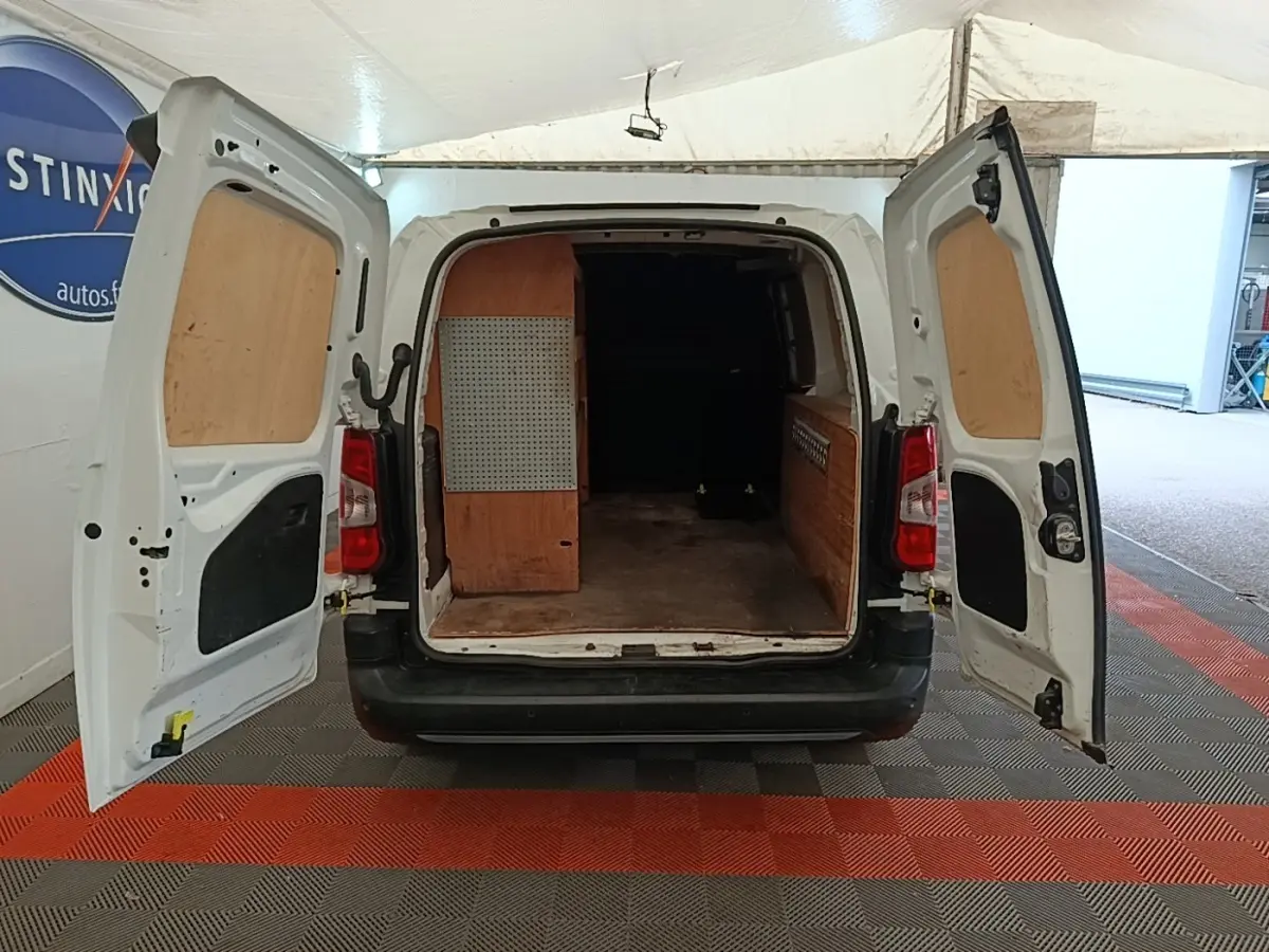 Vue arrière d’un Citroën Berlingo XL blanc 2020 avec portes arrière ouvertes et aménagement bois dans le coffre.