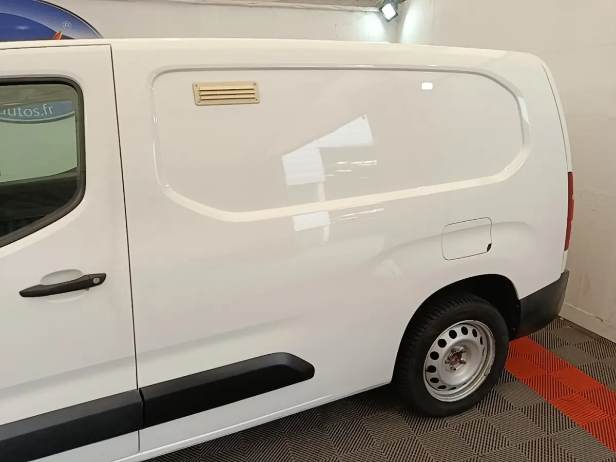 Vue de profil côté droit d'un utilitaire Citroën Berlingo XL blanc avec porte latérale pleine et jante acier.