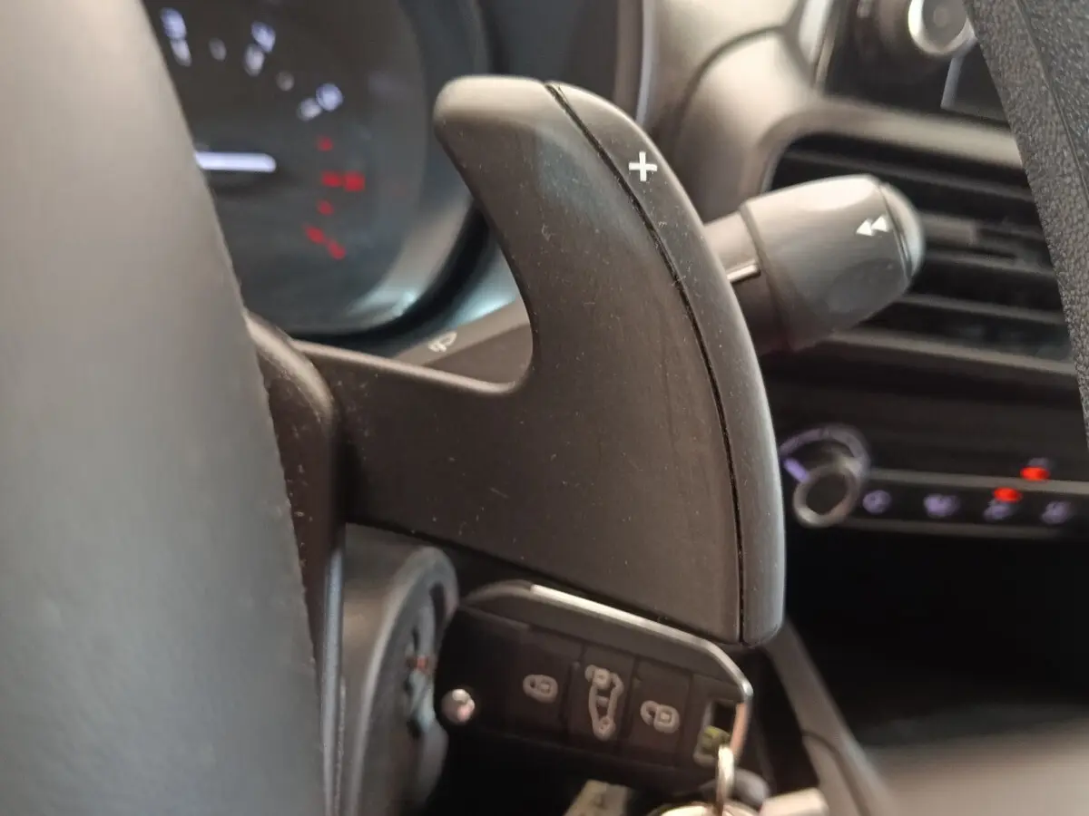 Gros plan sur la palette de changement de vitesse au volant du Citroën Berlingo blanc, intérieur noir.