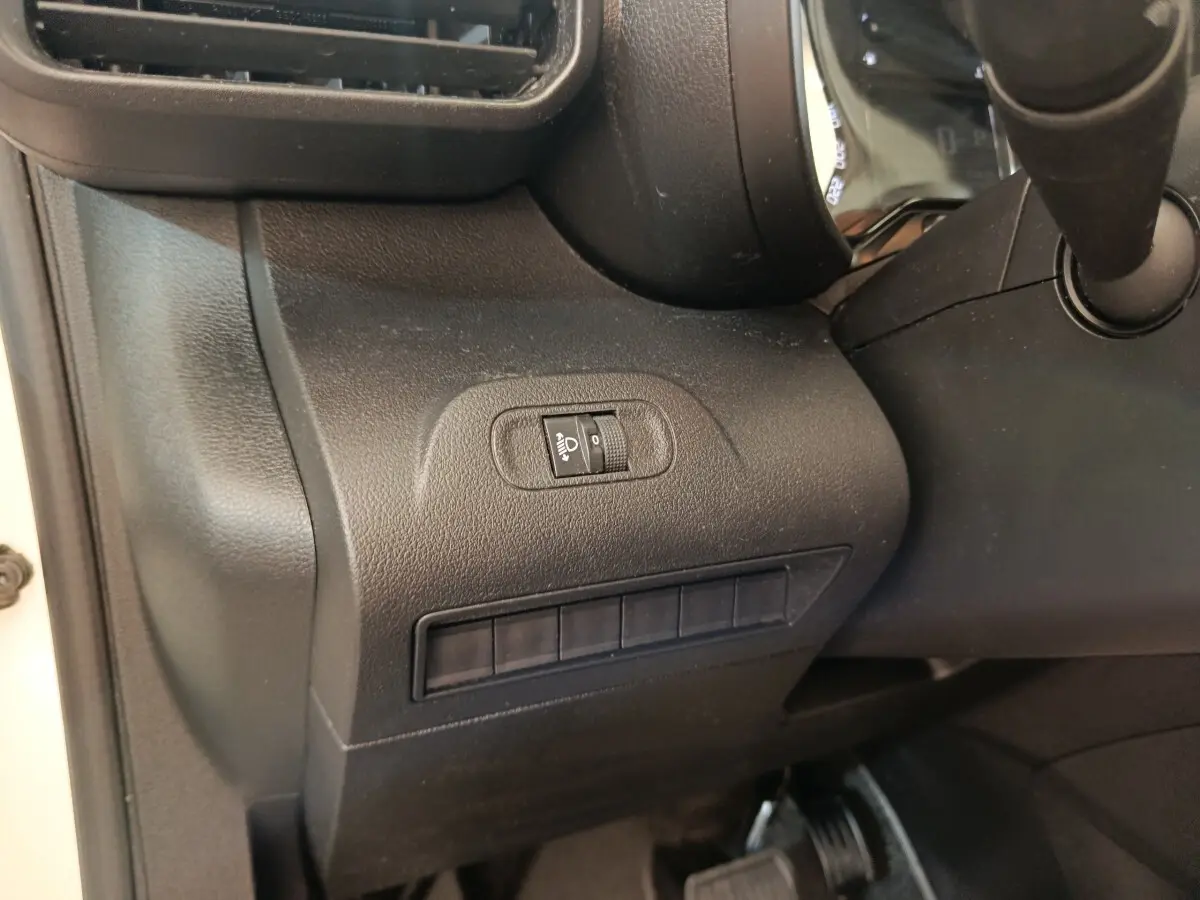Détail du tableau de bord côté gauche du Citroën Berlingo blanc 2020, avec commande de réglage hauteur des phares.