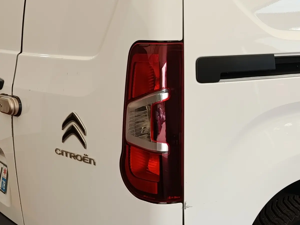 Gros plan sur le feu arrière droit et la porte arrière blanche d’un Citroën Berlingo utilitaire.
