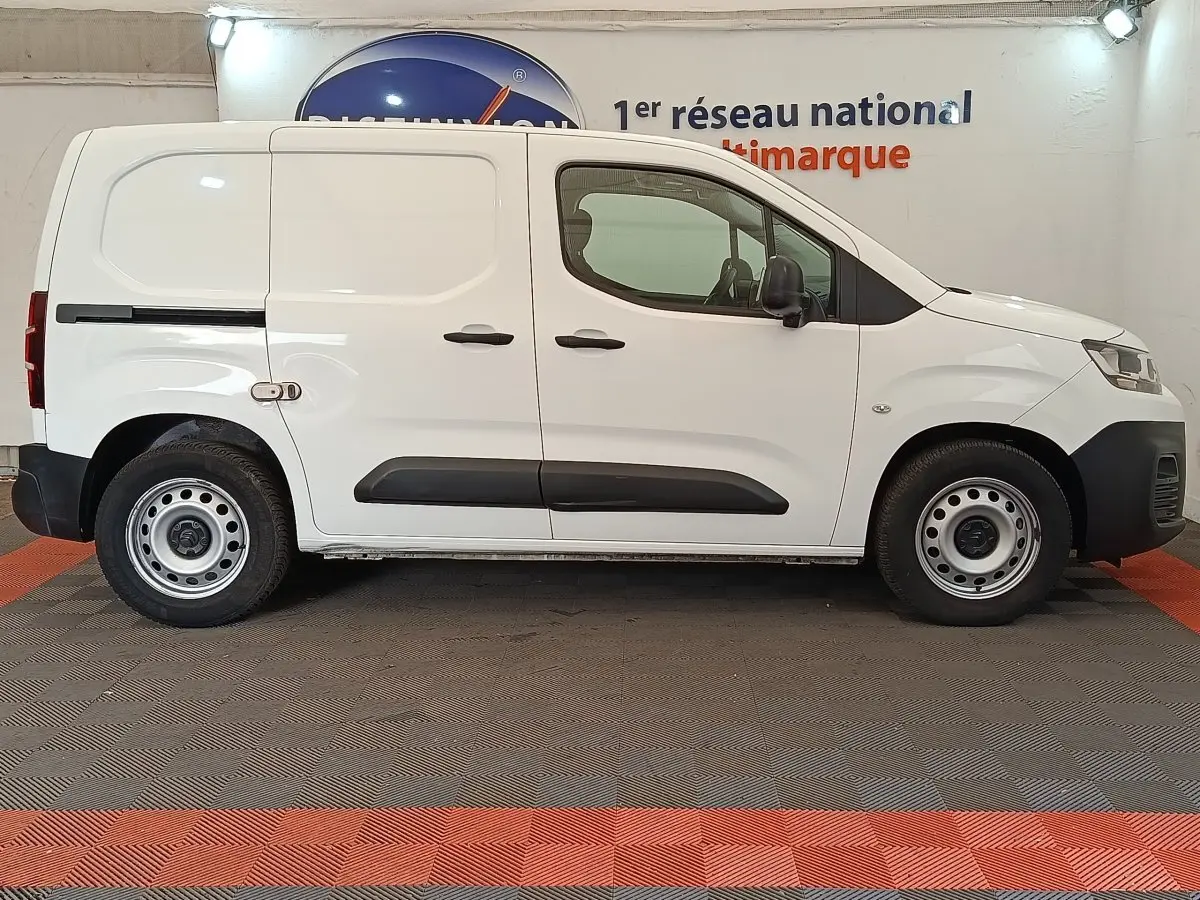 Vue de profil côté droit d’un utilitaire Citroën Berlingo blanc avec portes latérales pleines et jantes acier.