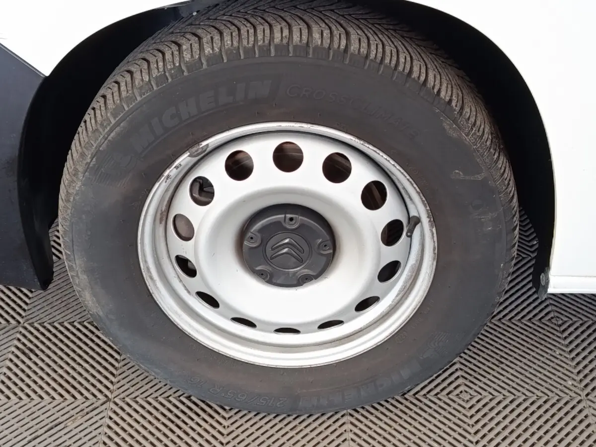 Gros plan sur la roue acier blanche avec logo Citroën d’un Citroën Berlingo blanc, côté gauche.