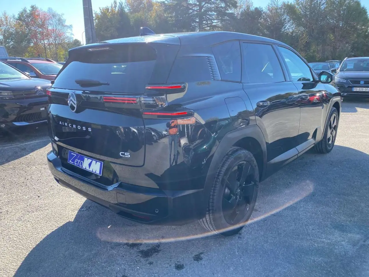 Vue 3/4 arrière droite d'un Citroën C5 Aircross noir brillant avec jantes alliage noires et feux arrière LED distinctifs.