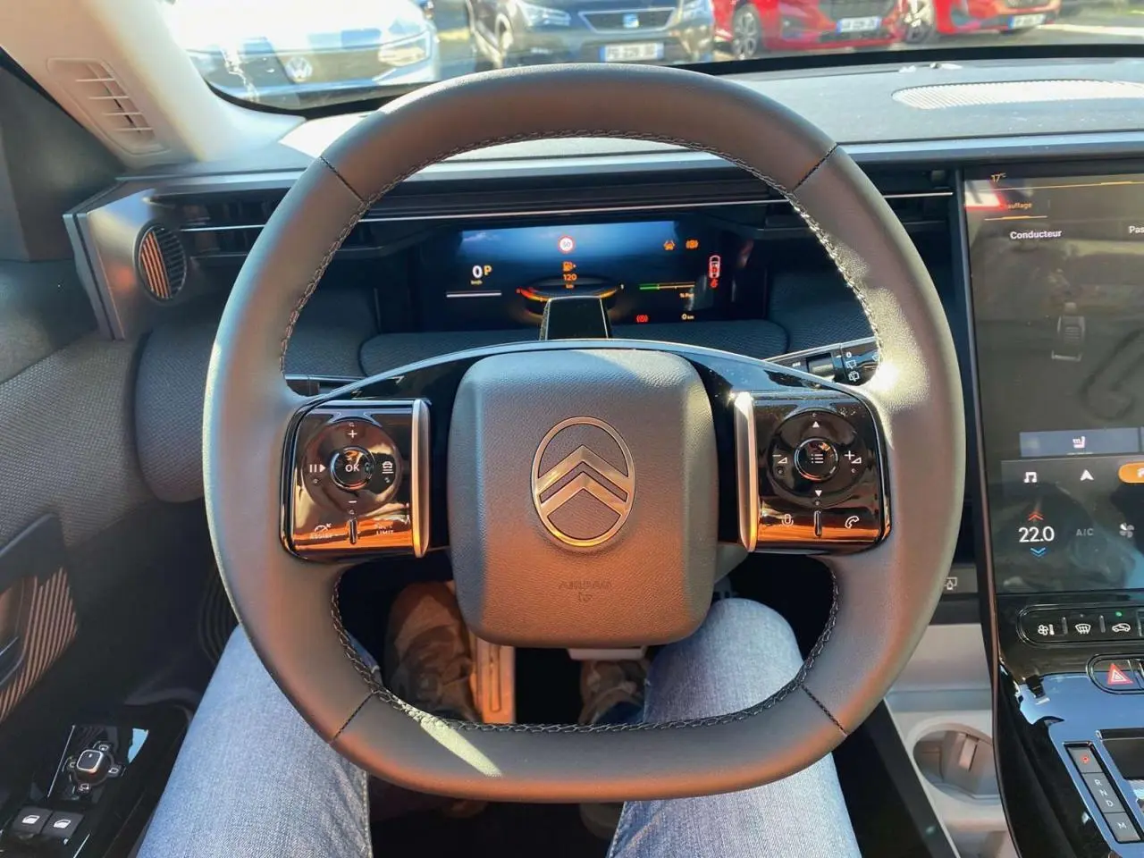 Vue intérieure centrée sur le volant du Citroën C5 Aircross 2026, avec tableau de bord numérique et écran tactile visible.