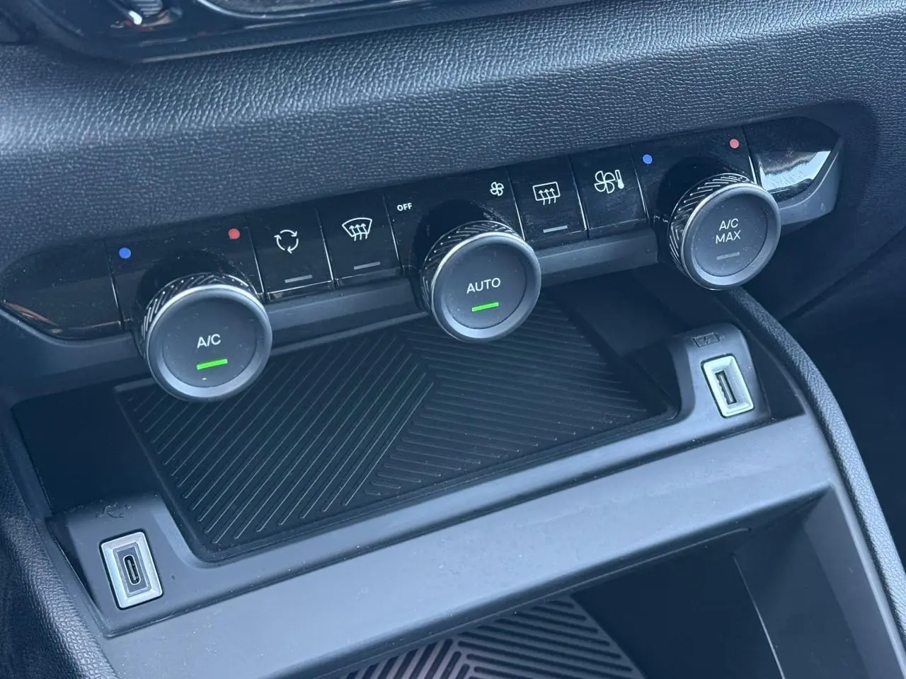 Commandes de climatisation automatique avec boutons rotatifs et ports USB dans l'habitacle noir du Citroën C4 X 2024