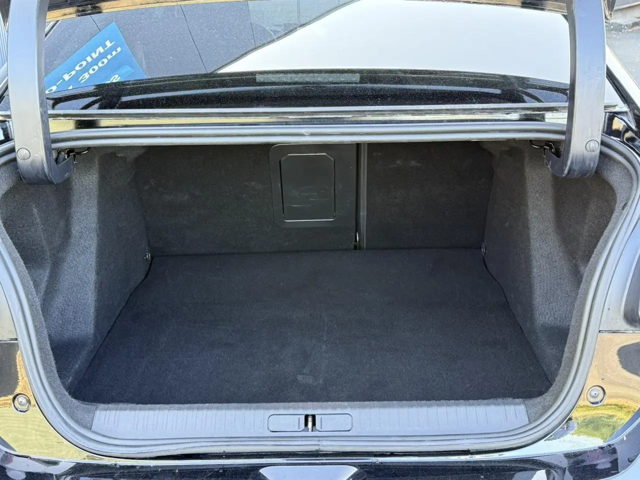 Coffre ouvert vu de l'arrière d'une Citroën C4 X 2024 noir Perla, espace de chargement vide et propre.