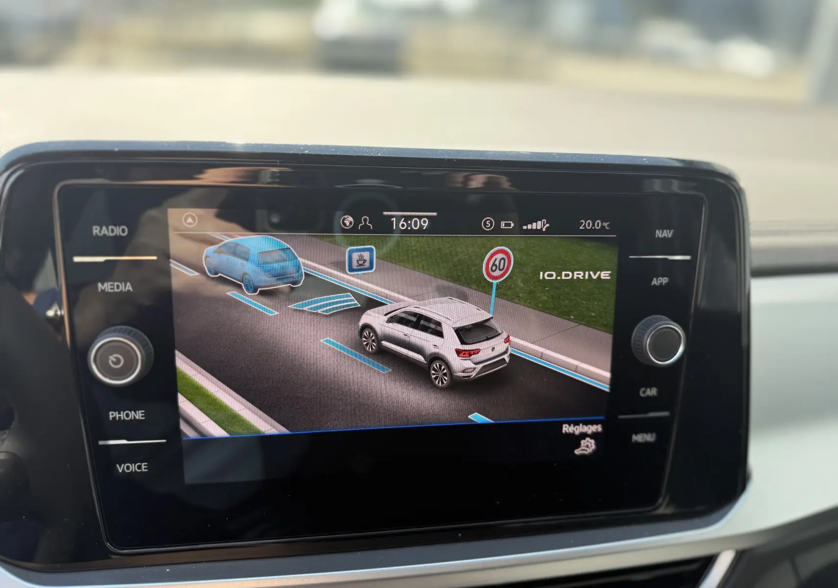 Écran central affichant l'interface IQ.DRIVE du Volkswagen T-Roc gris pyrite avec signalisation 60 km/h visible.