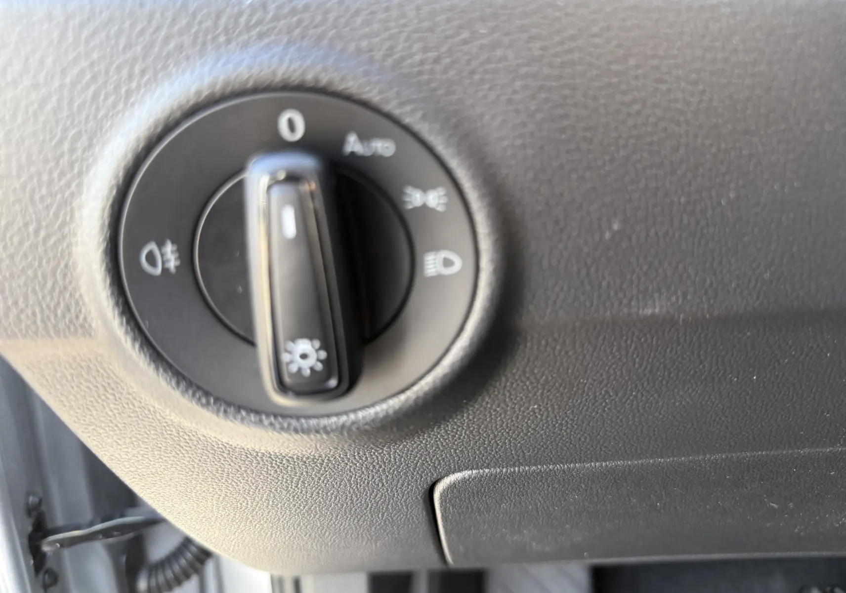 Gros plan sur le sélecteur d'éclairage intérieur du Volkswagen T-Roc 2025 gris pyrite, côté conducteur.