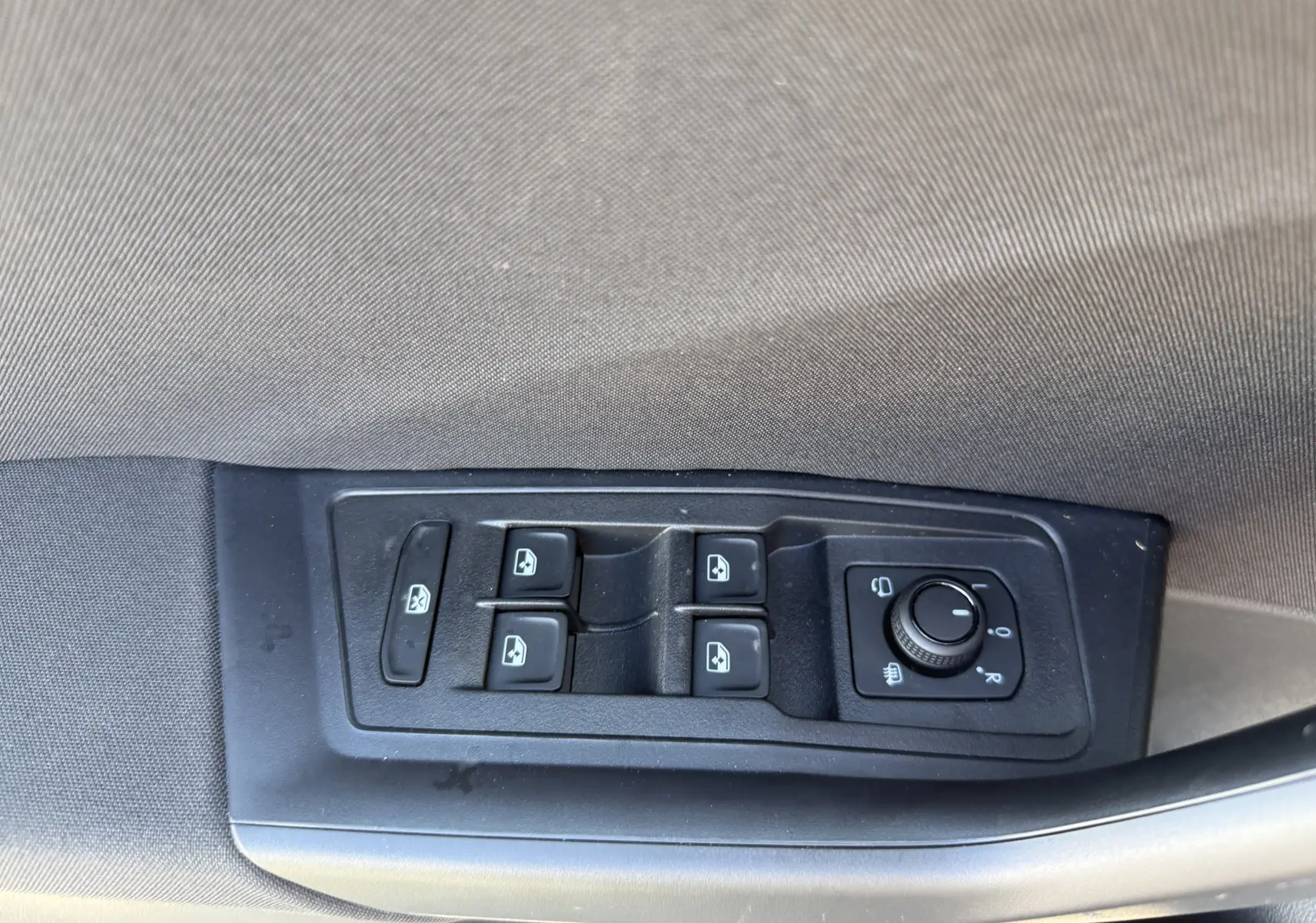 Panneau de commandes des vitres et rétroviseurs côté gauche intérieur d'un Volkswagen T-Roc gris pyrite 2025.