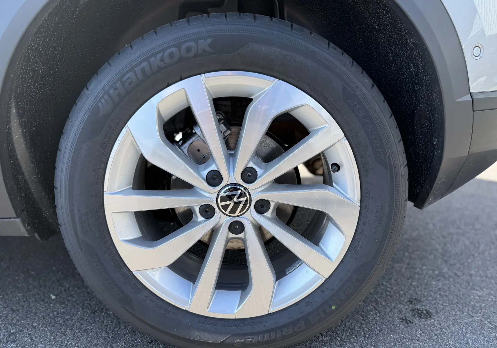 Gros plan sur la jante aluminium 17 pouces du Volkswagen T-Roc gris pyrite, mettant en valeur le pneu Hankook et le logo VW central.