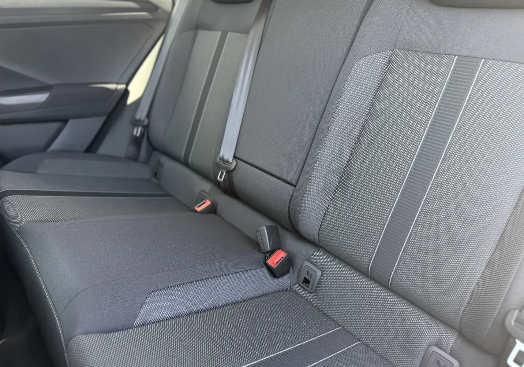 Vue rapprochée des sièges arrière gris foncé du Volkswagen T-Roc 1.5 TSI 150 DSG7 avec ceintures et fixations ISOFIX visibles.
