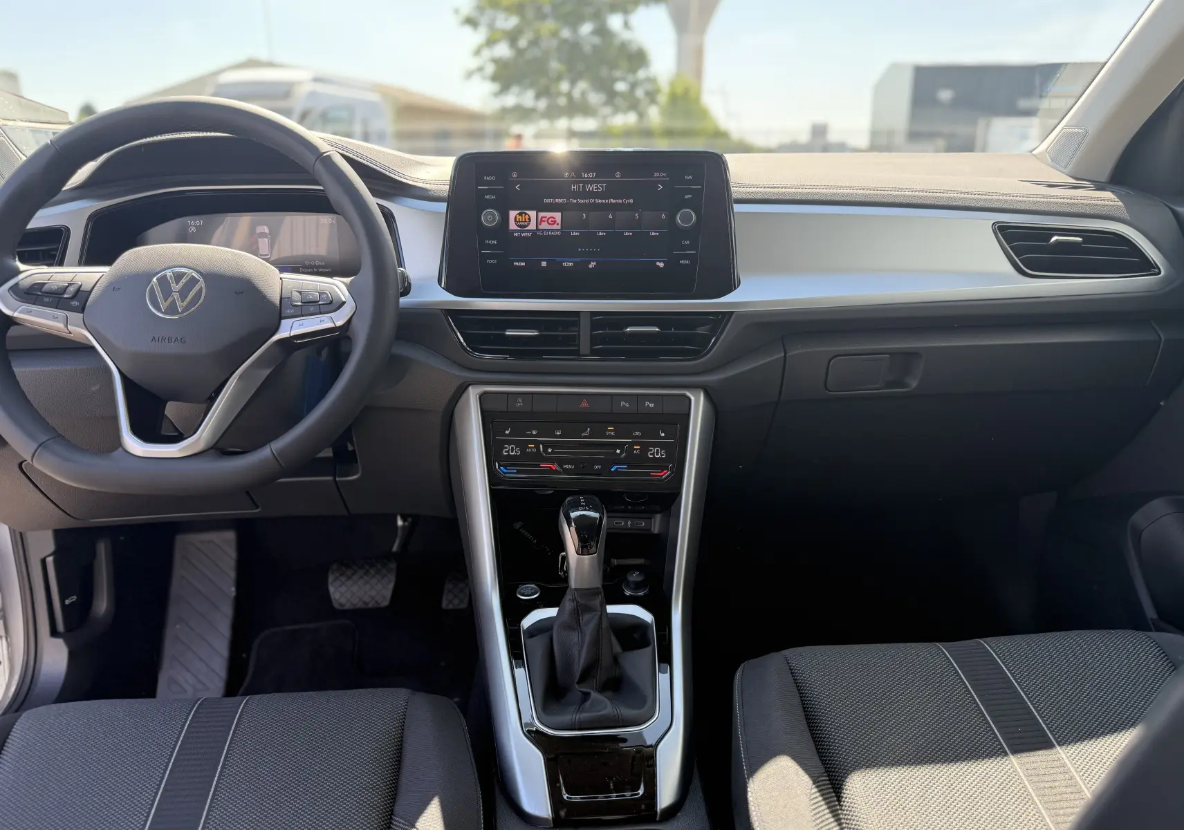 Vue intérieure avant du Volkswagen T-Roc 1.5 TSI 150 DSG7 LIFE 2025, tableau de bord moderne avec écran tactile et volant multifonction.
