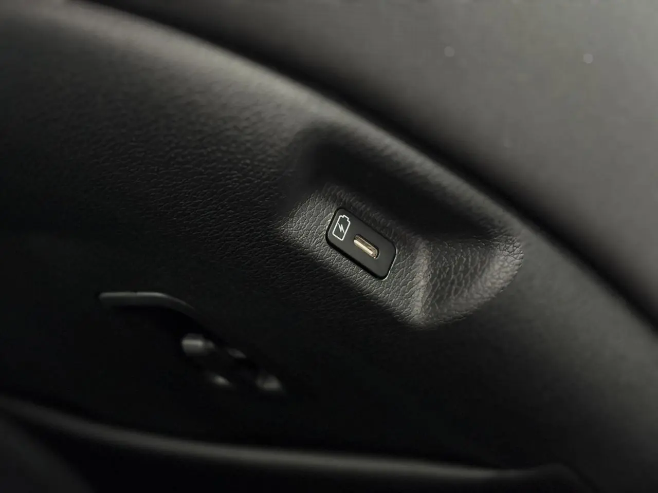 Prise USB-C intégrée dans l'accoudoir central avant du Kia Sportage gris perle 2025, finition Style.