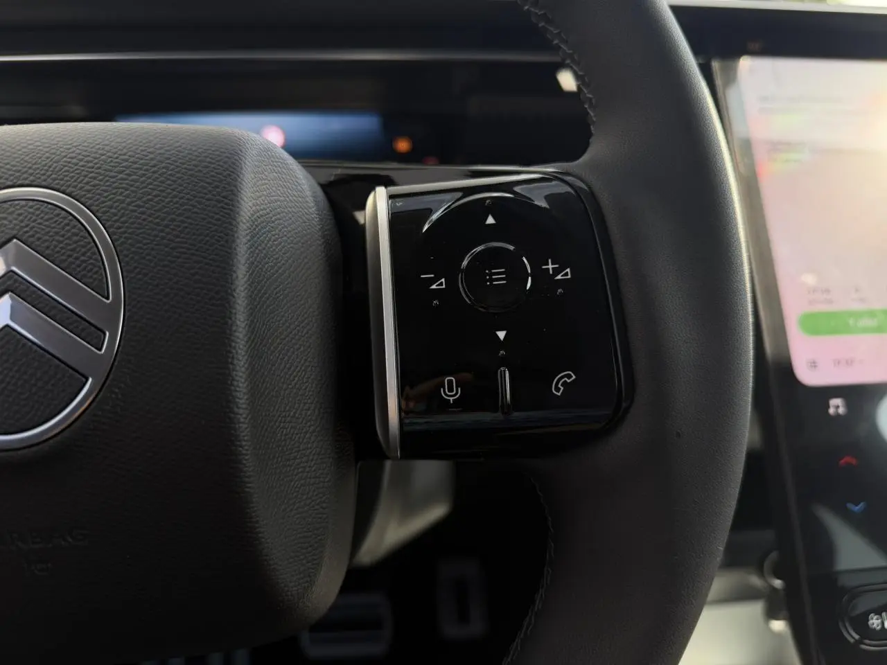 Gros plan sur le volant noir du Citroën C5 Aircross 2026 avec commandes tactiles et logo central argenté.