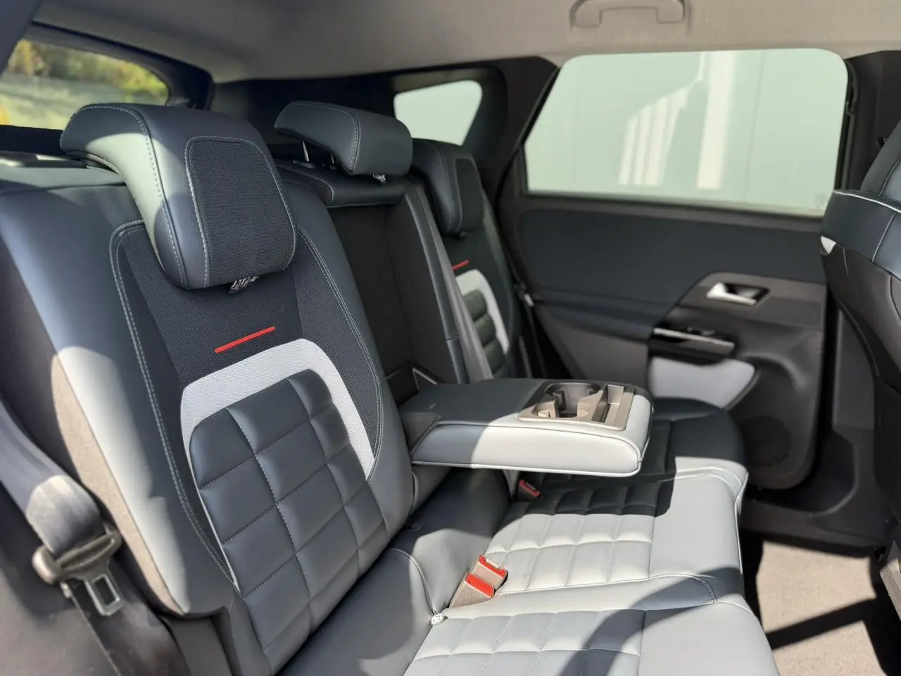 Vue intérieure côté droit des sièges arrière en cuir noir et gris du Citroën C5 Aircross 2026 avec accoudoir central déployé.