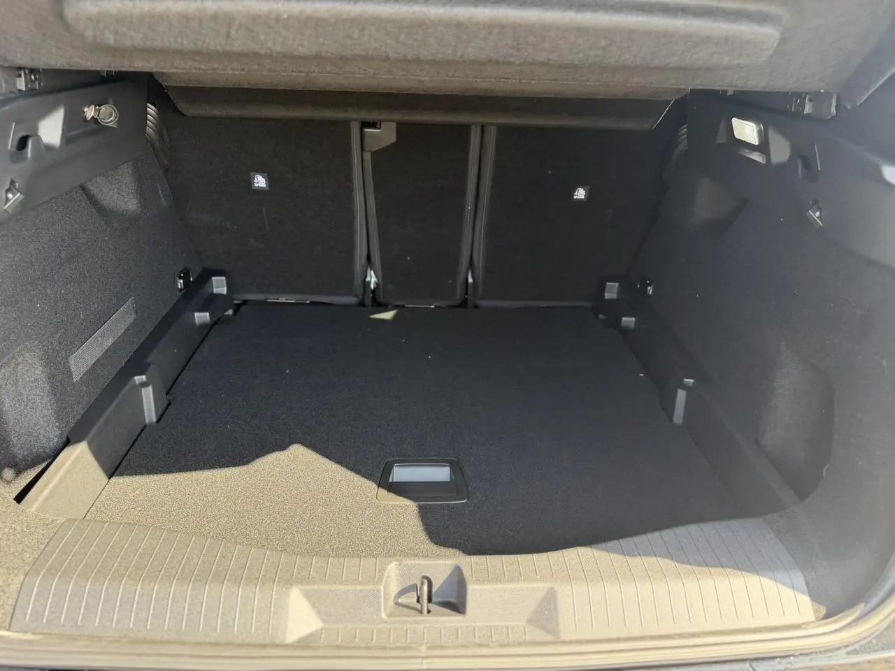 Coffre spacieux ouvert du Citroën C5 Aircross noir Perla, avec plancher plat et banquette arrière rabattue partiellement.
