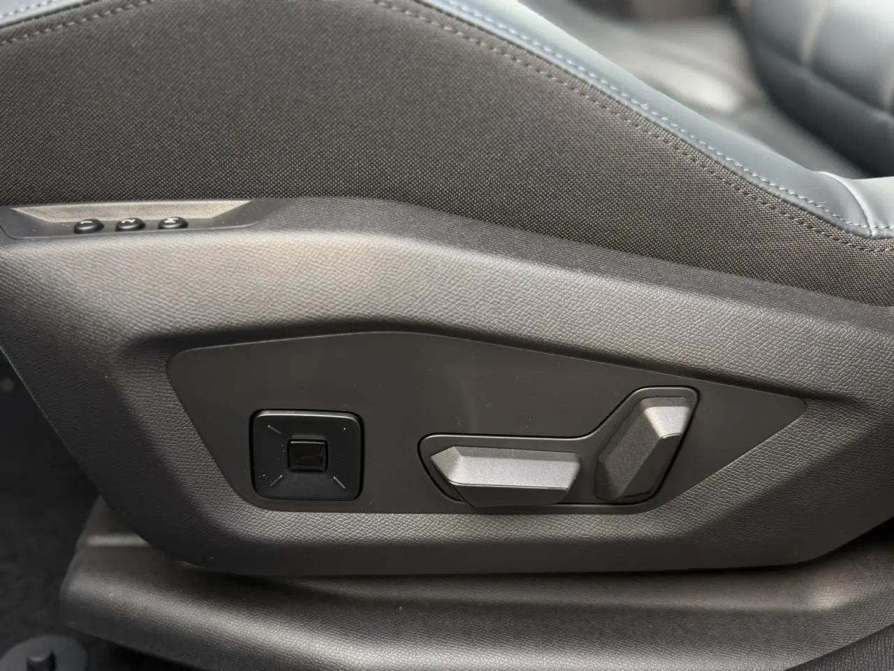Gros plan sur les commandes électriques de réglage du siège avant côté conducteur du Citroën C5 Aircross noir Perla.
