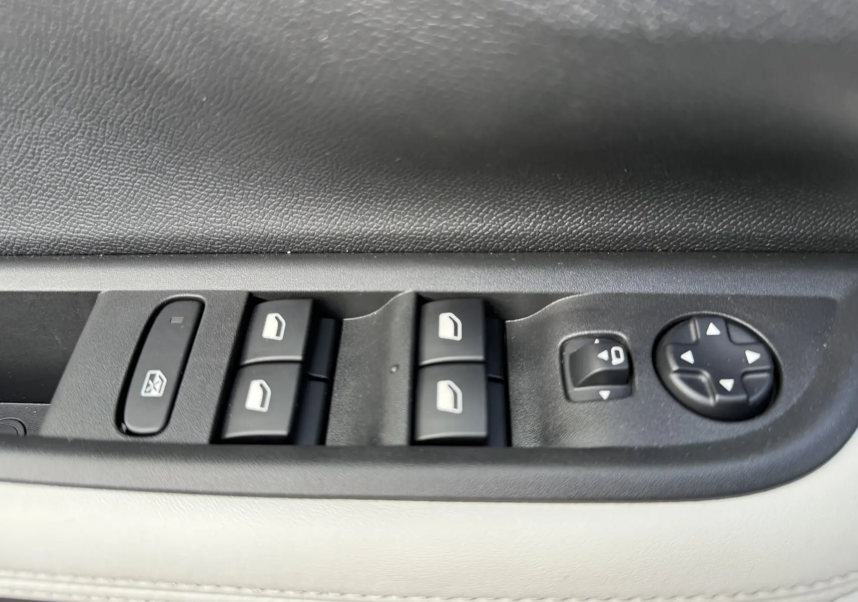 Gros plan sur les commandes de lève-vitres et réglage des rétroviseurs côté conducteur d'une Citroën C3 Aircross blanc banquise toit noir.