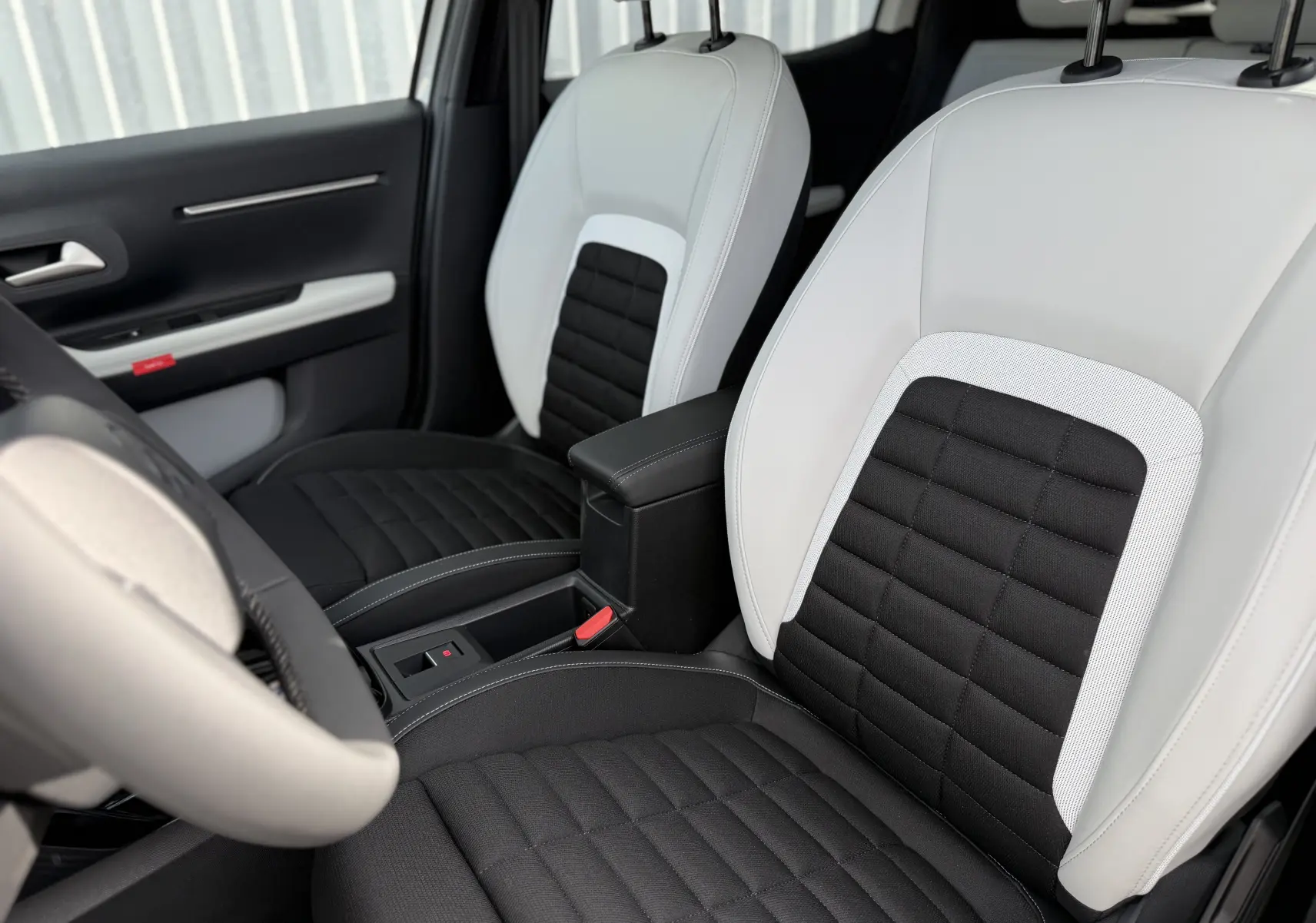 Vue intérieure rapprochée des sièges avant bicolores noir et blanc du Citroën C3 Aircross Hybrid 145 e-DSC6 Max.