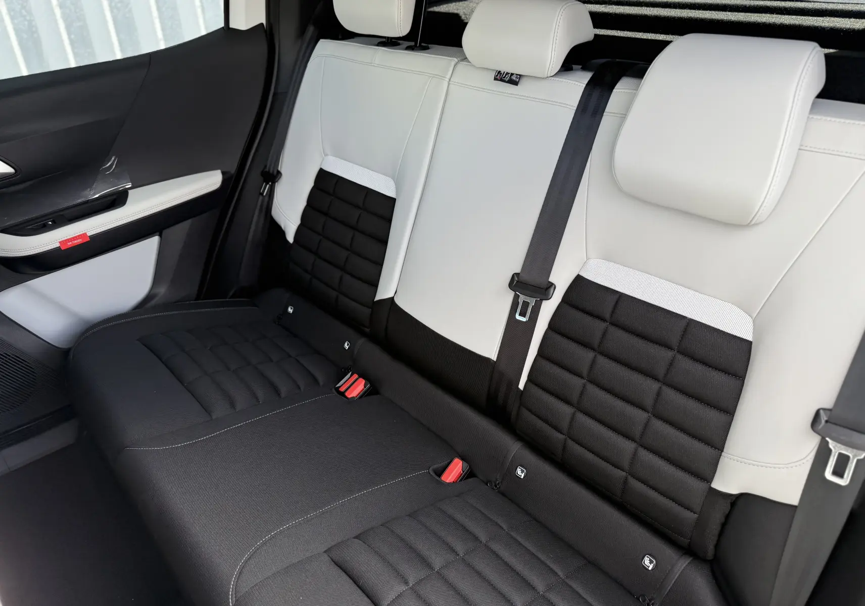 Vue intérieure arrière côté droit des sièges bicolores noir et blanc du Citroën C3 Aircross Hybrid 145 e-DSC6 Max 2026.