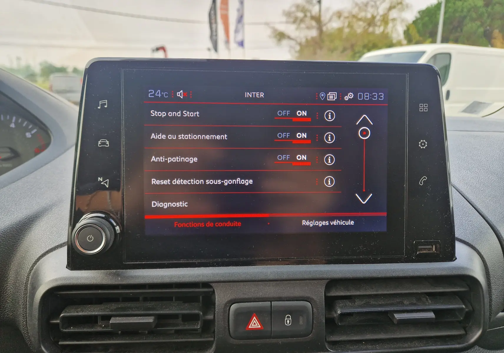 Écran tactile central du Peugeot Partner 2021 affichant les réglages d’aides à la conduite, avec commandes et ventilation visibles.