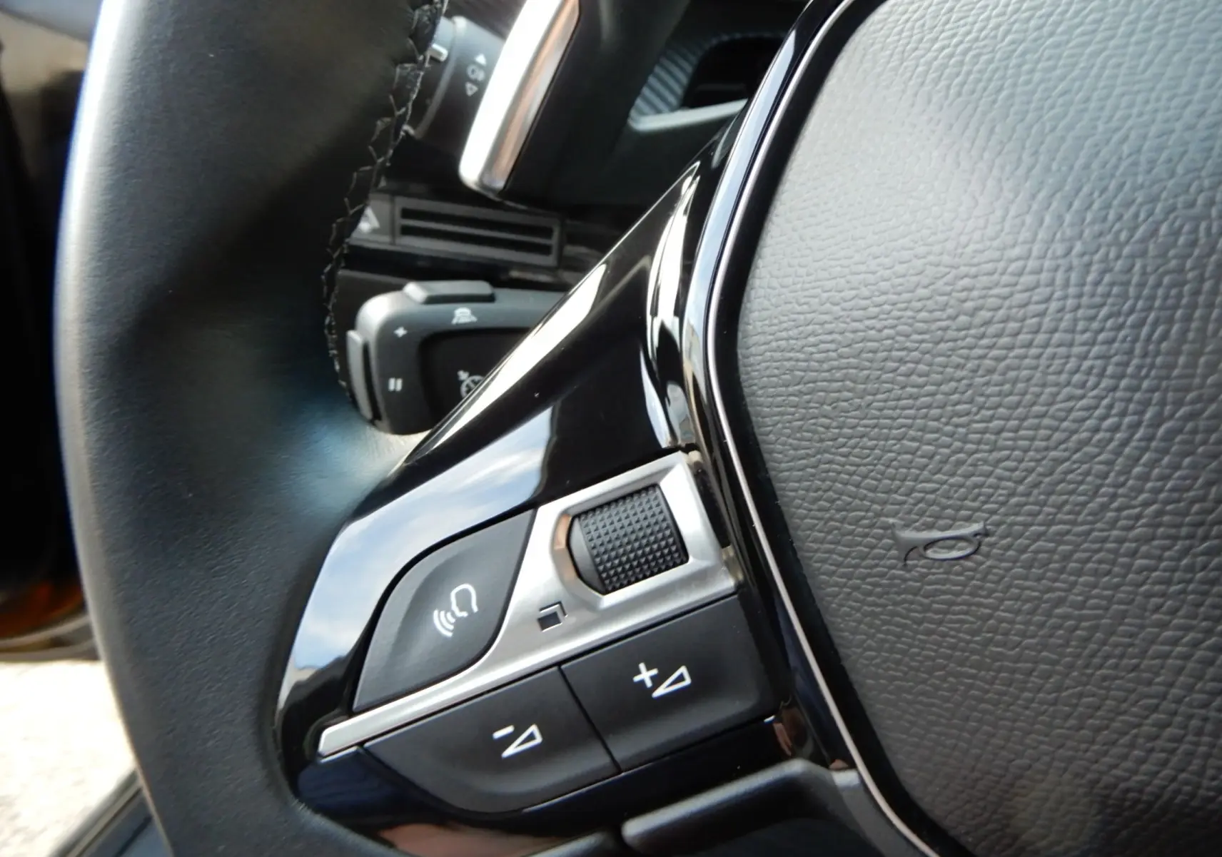 Gros plan sur les commandes de volume et téléphone du volant noir du Peugeot 508 SW Allure 2020.
