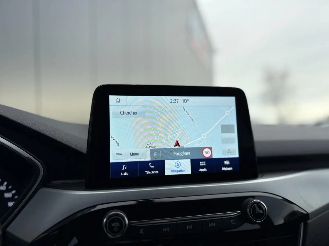 Écran tactile GPS du Ford Kuga 2024 affichant une carte de navigation, vue intérieure centrée sur la console.