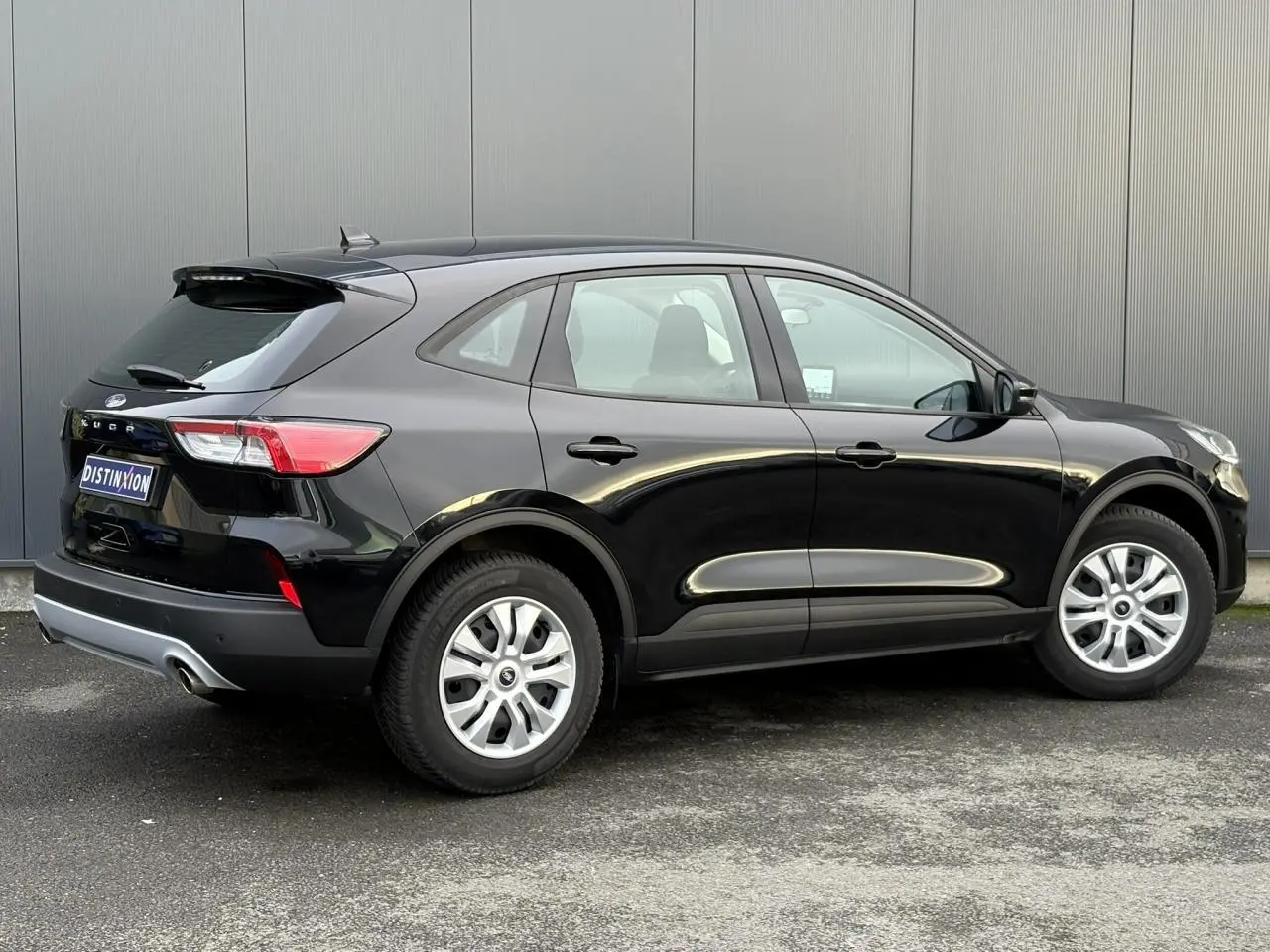 Vue latérale droite du Ford Kuga 2024 noir Obsidien, soulignant ses lignes fluides et ses jantes argentées.