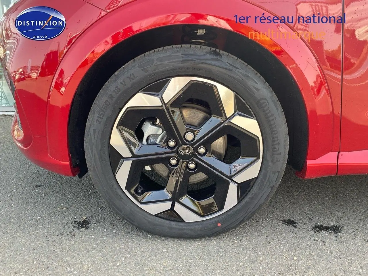 Gros plan sur la roue avant droite avec jante alu noire et argentée du Ford Puma rouge Fantastic Métallisée.