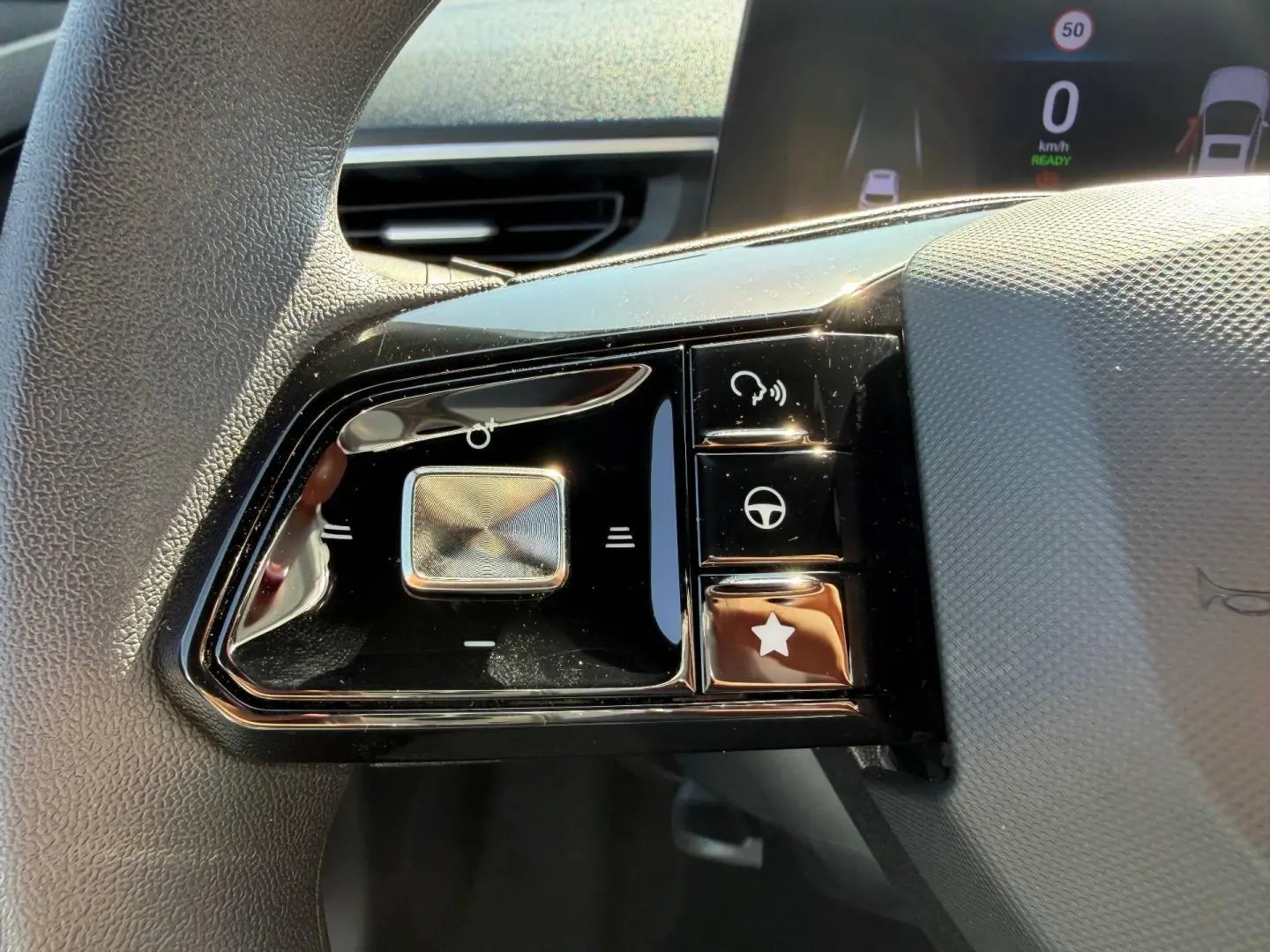 Gros plan sur les commandes noires brillantes du volant multifonction du MG3 1.5 Hybrid+ 2025, avec touches tactiles.