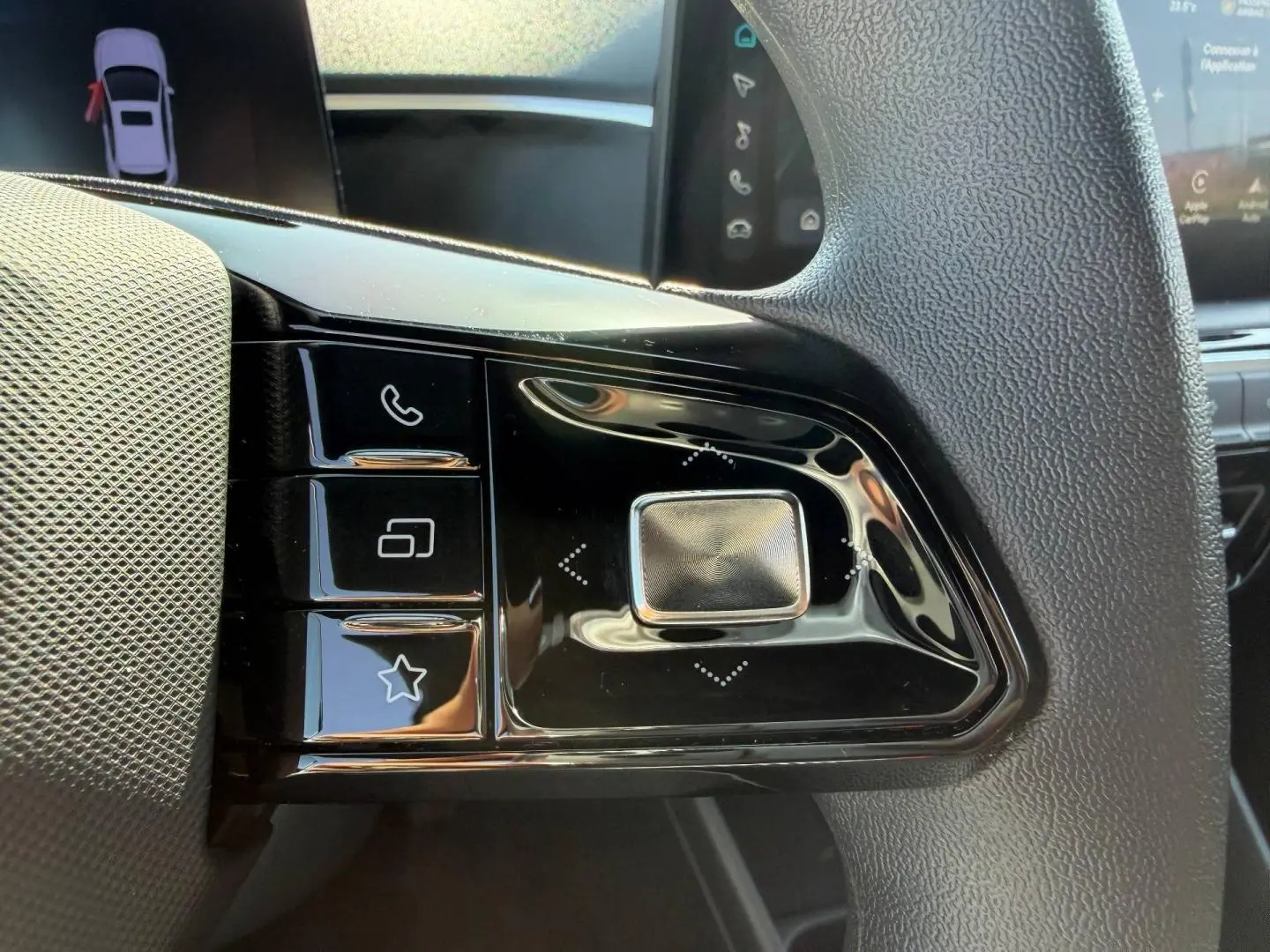 Gros plan sur les commandes multifonctions noires à gauche du volant de la MG3 1.5 Hybrid+ 2025, intérieur noir.