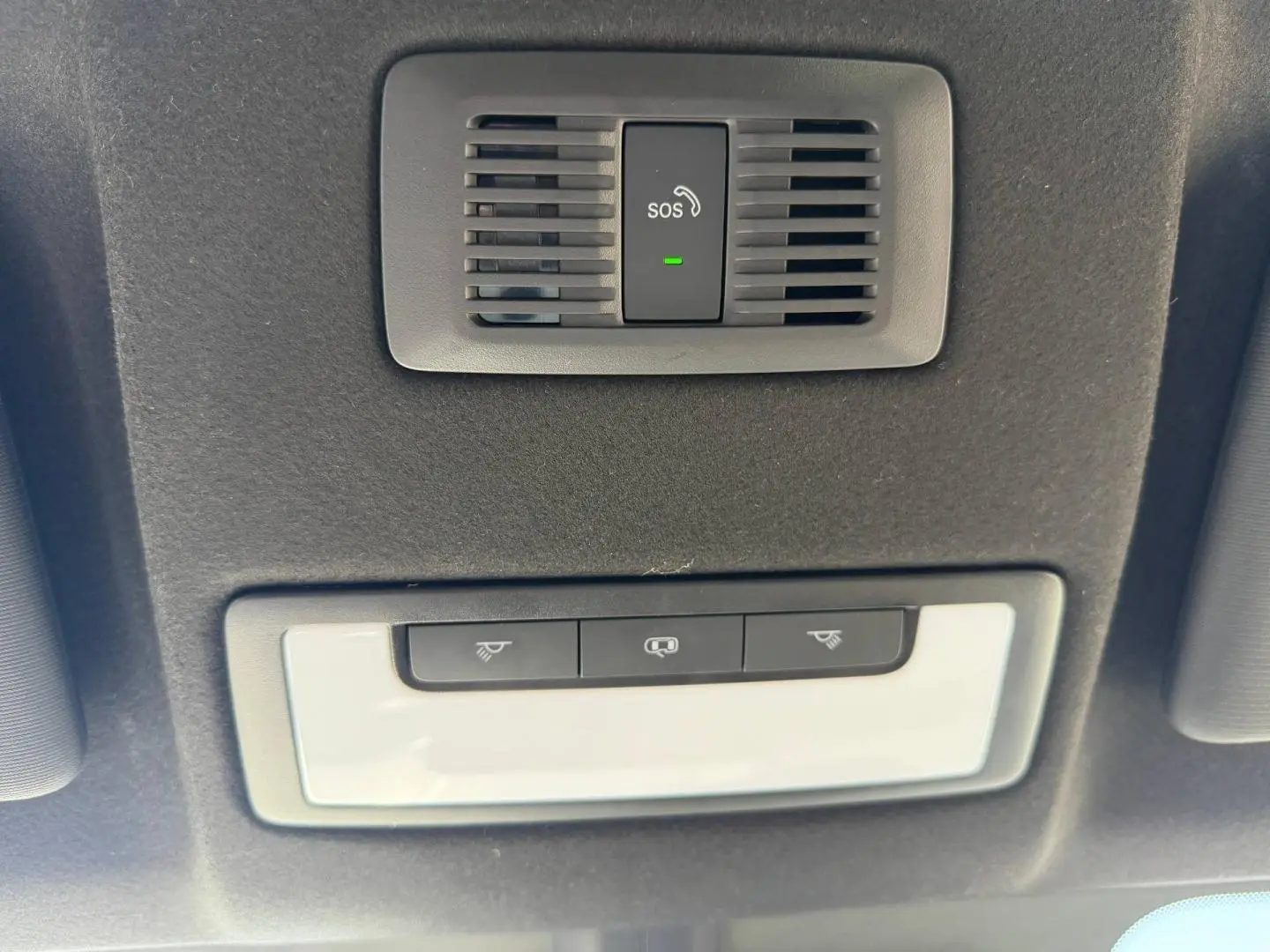 Vue en contre-plongée du plafonnier noir avec bouton SOS et commandes d'éclairage blanc dans un MG MOTOR MG3 2025 hybride.