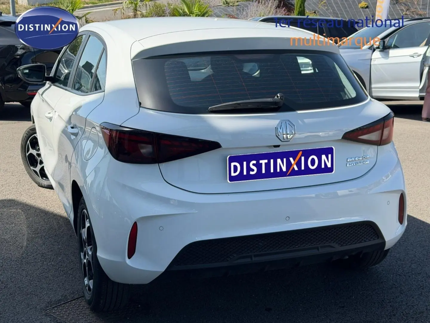 Vue 3/4 arrière droite de la MG3 1.5 Hybrid+ blanche avec feux arrière fumés et jantes alliage noires.