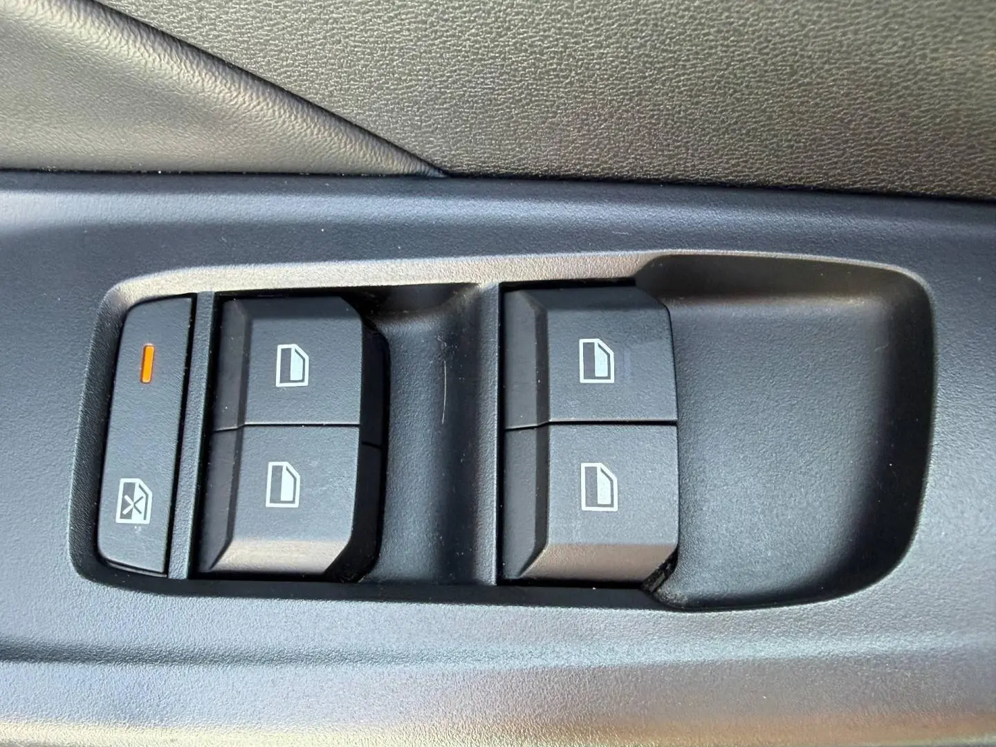 Gros plan sur les commandes de lève-vitres électriques côté conducteur du MG3 1.5 Hybrid+ 2025 en plastique noir.