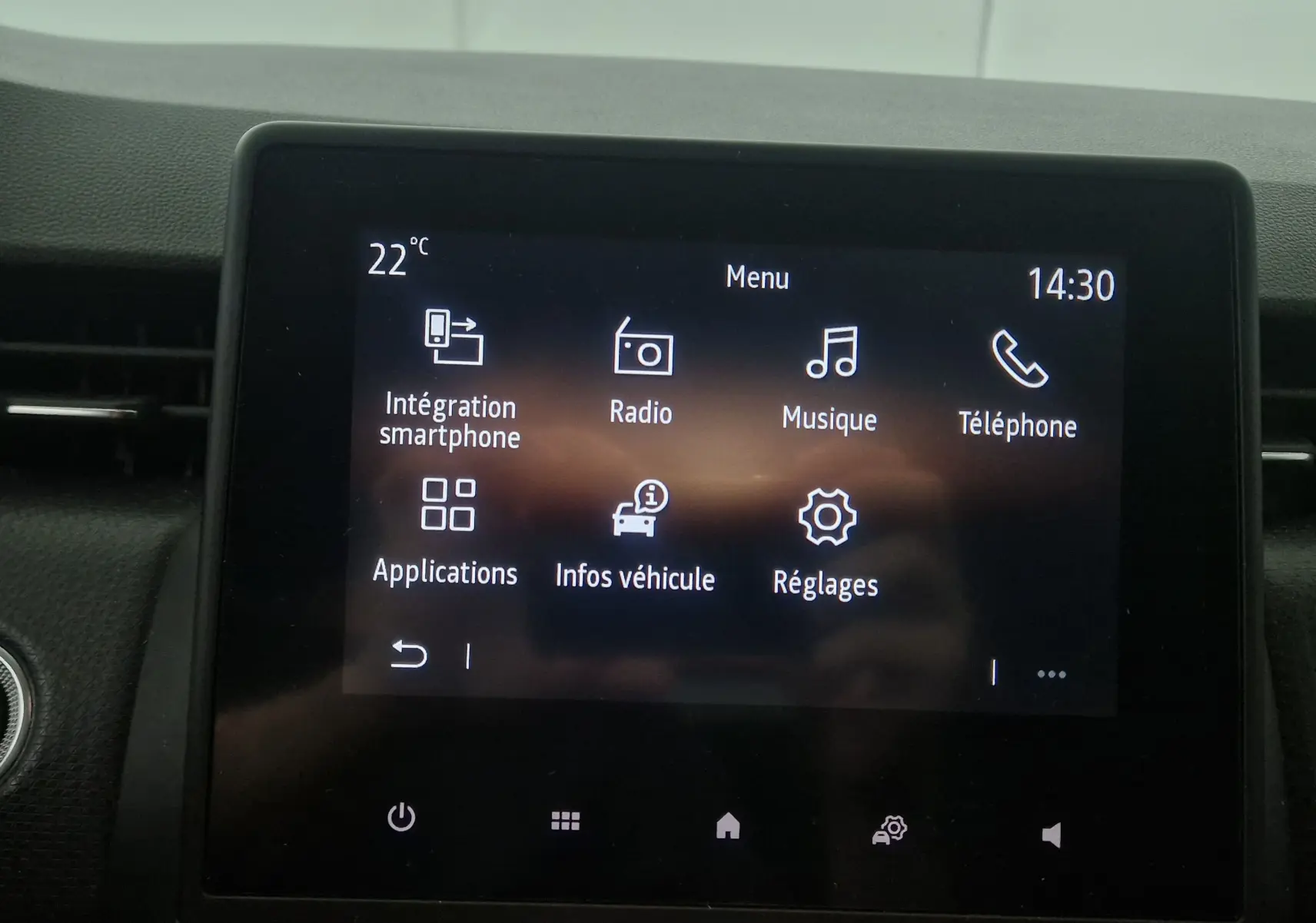 Écran tactile central de la Renault Clio V gris platine, affichant le menu multimédia avec options smartphone et radio.