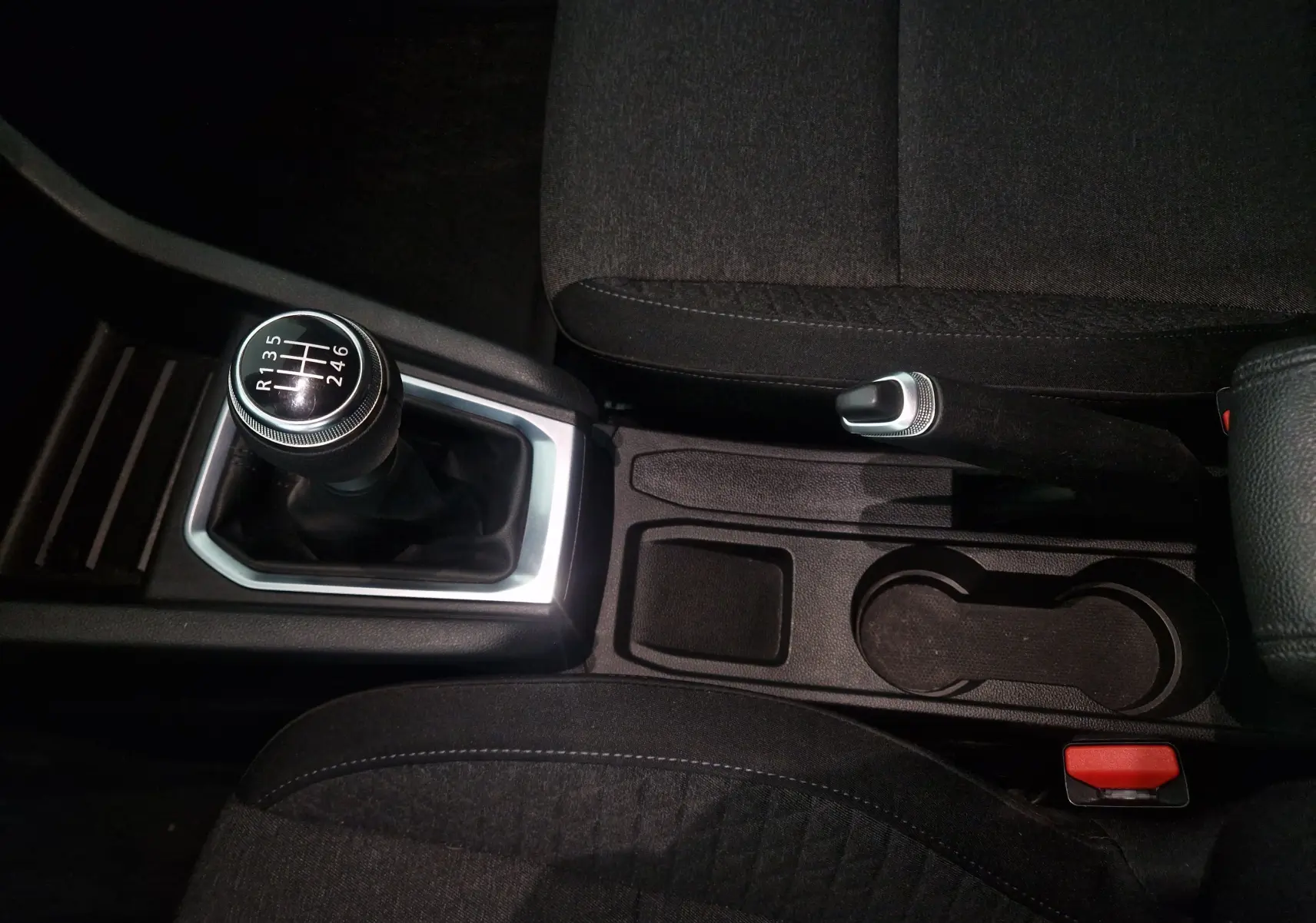 Vue rapprochée de la console centrale de la Renault Clio V gris platine, mettant en valeur le levier de vitesses manuel et le frein à main.