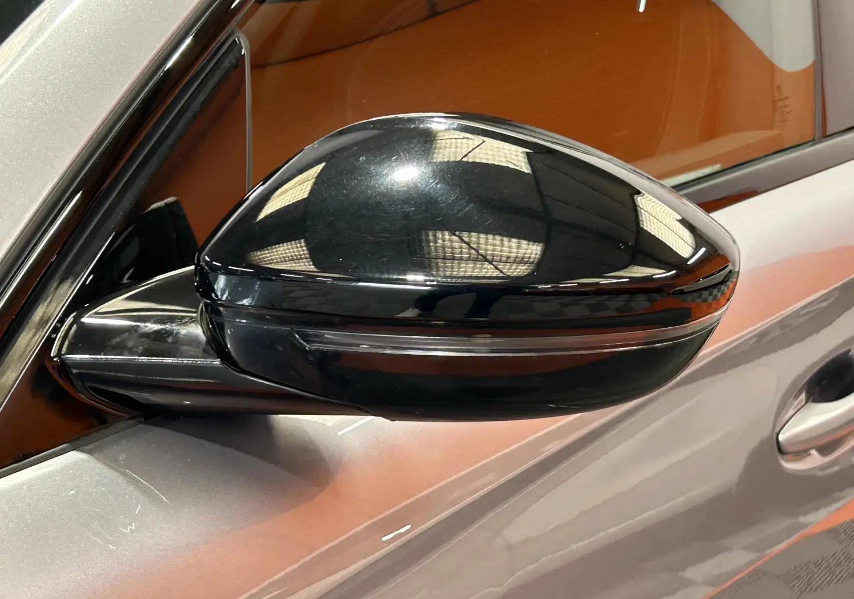 Rétroviseur extérieur noir côté gauche d'une Peugeot 508 SW 2024 gris artense avec intérieur cuir marron visible.