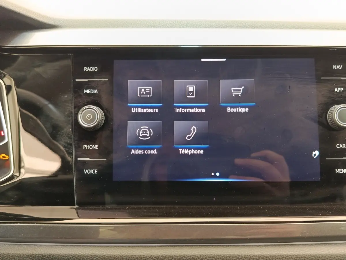 Écran tactile central affichant le menu des aides à la conduite dans l’habitacle du Volkswagen Taigo gris foncé.