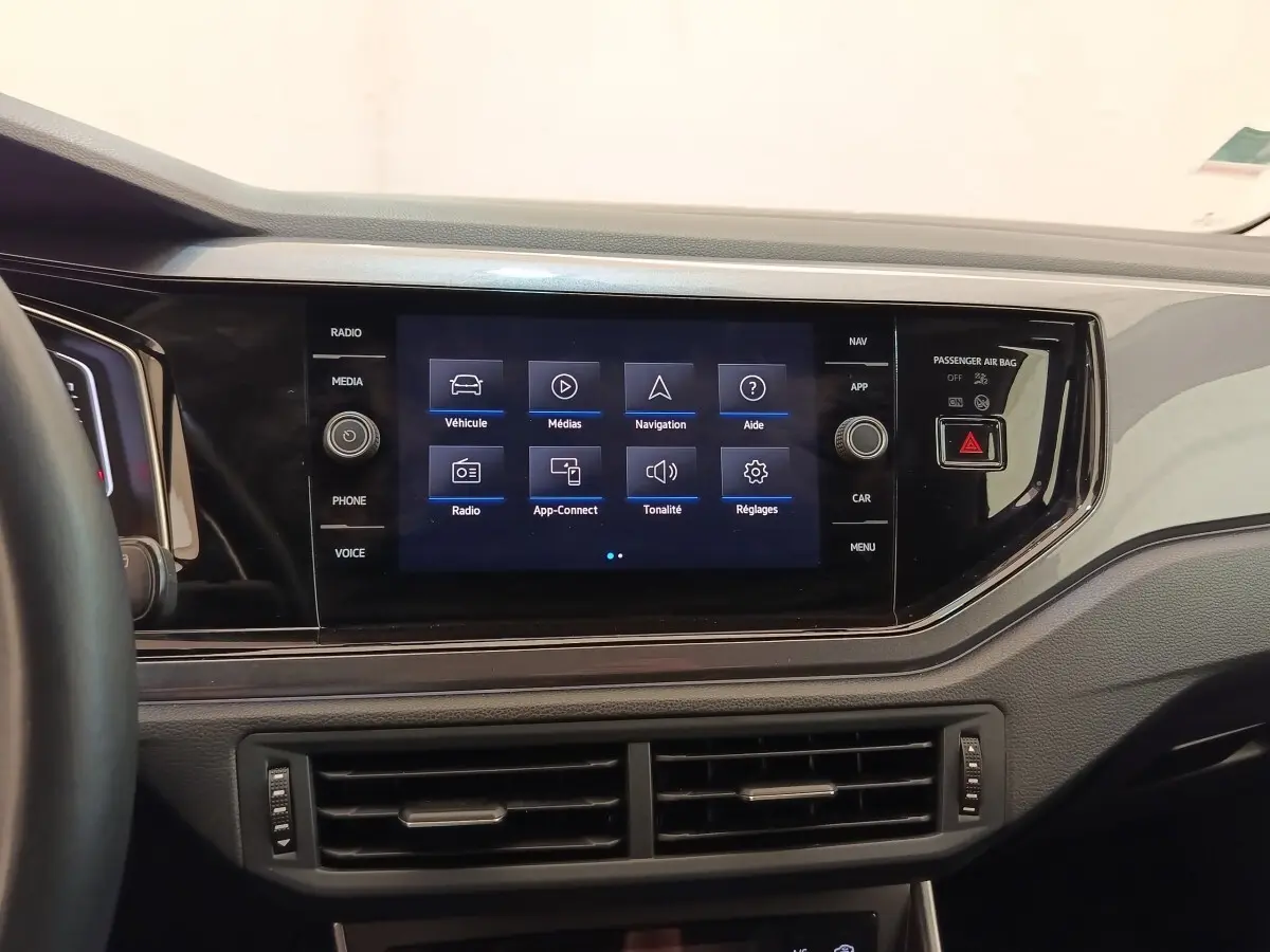 Vue rapprochée du tableau de bord noir du Volkswagen Taigo 1.5 TSI 150 DSG Style avec écran tactile central allumé.