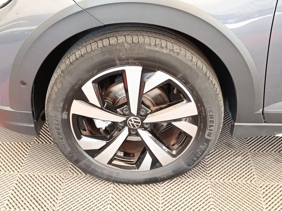 Gros plan sur la roue avant gauche gris foncé du Volkswagen Taigo 2023 avec jante alliage bicolore et logo VW.