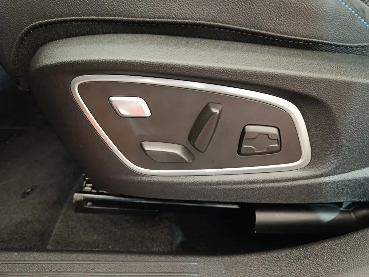 Gros plan sur les commandes électriques de réglage du siège avant en cuir noir du Renault Austral gris clair 2024.