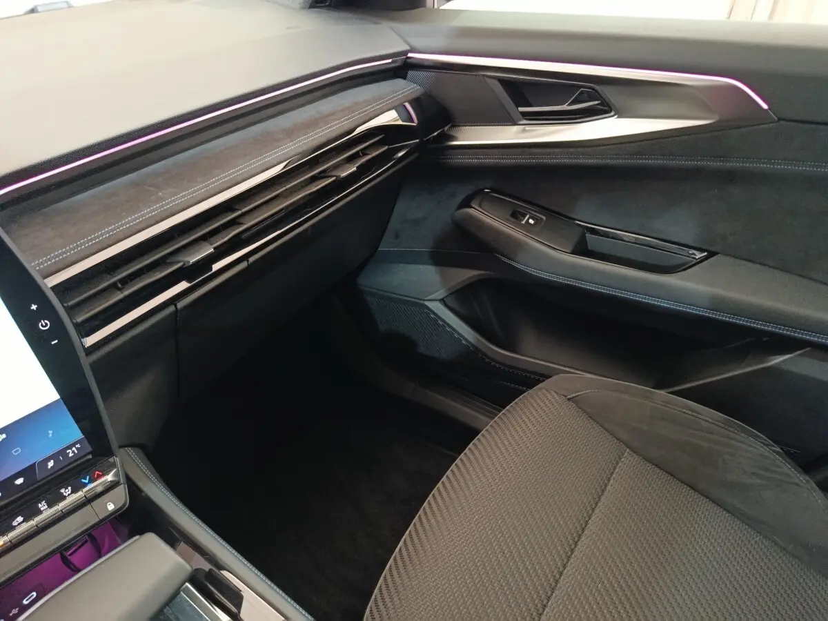 Vue intérieure côté passager du tableau de bord et porte avec éclairage d'ambiance violet du Renault Austral Iconic Esprit Alpine.