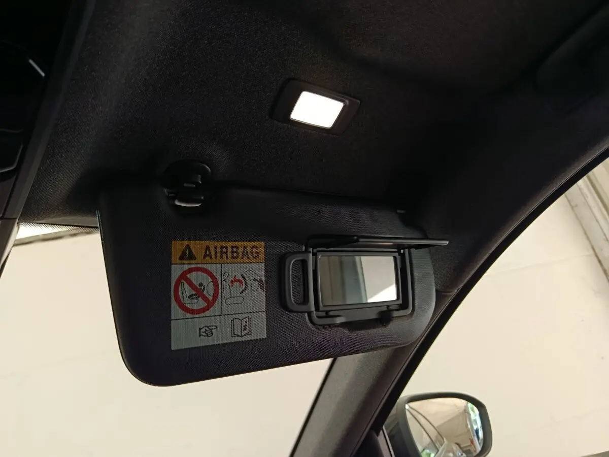 Détail intérieur montrant le pare-soleil gauche avec miroir et avertissement airbag dans un Renault Austral gris clair.