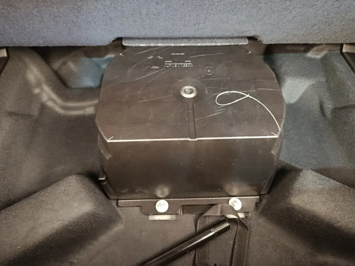 Vue rapprochée du compartiment de coffre du Renault Austral gris clair, montrant un boîtier noir central.