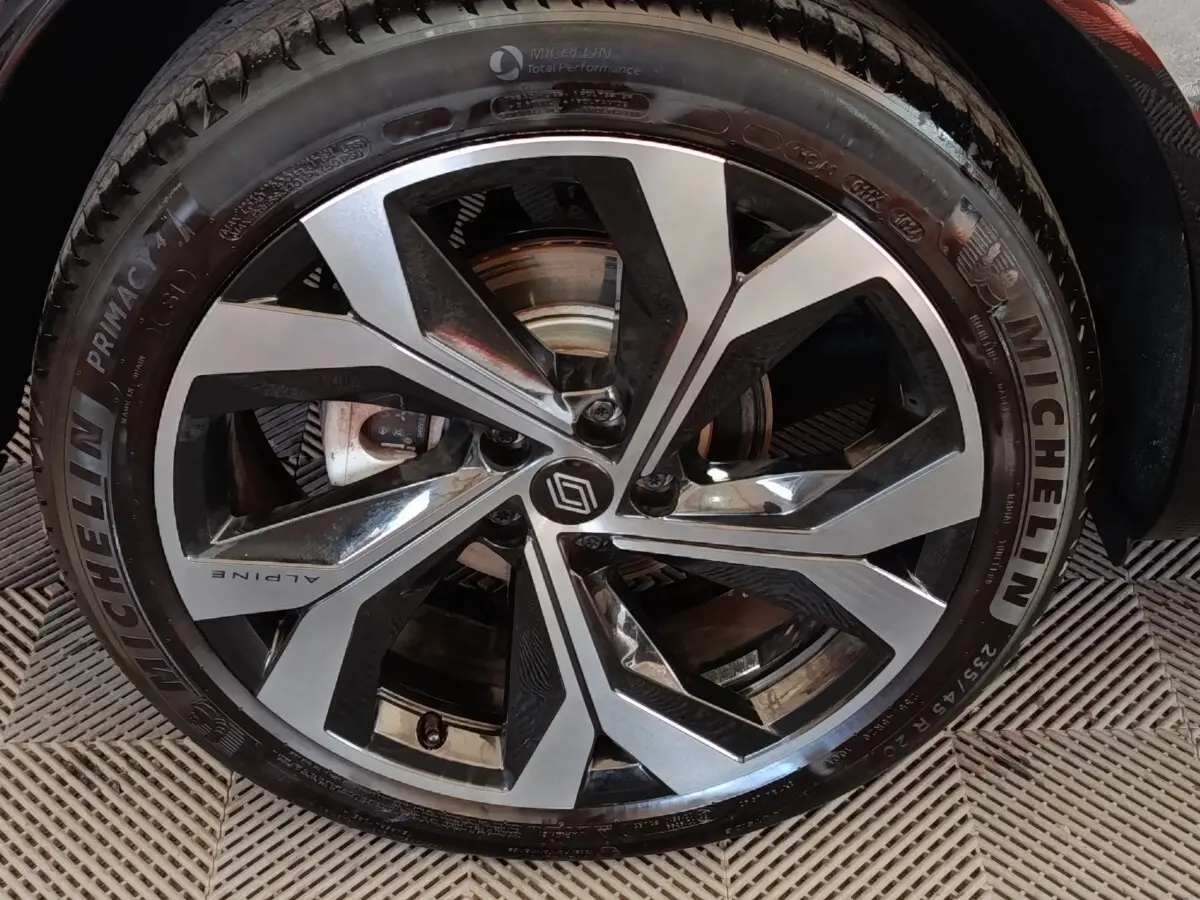 Gros plan sur la roue avant droite du Renault Austral gris clair avec jante Alpine et pneu Michelin.