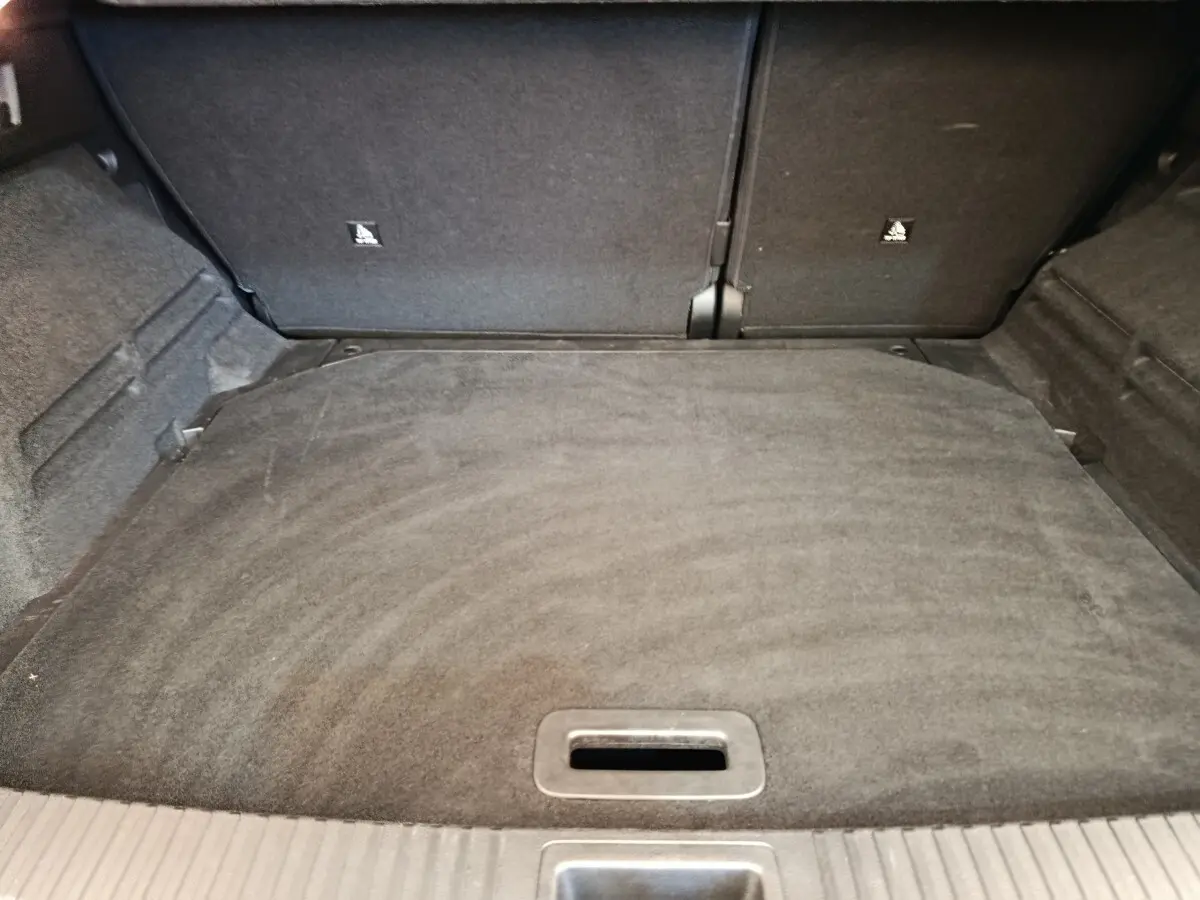 Coffre vide du Renault Austral gris clair, vue intérieure depuis l'ouverture arrière, avec banquette arrière rabattable.