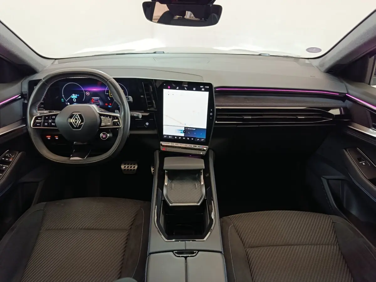 Vue intérieure frontale du tableau de bord du Renault Austral 2024 avec écran tactile vertical et éclairage d’ambiance violet.