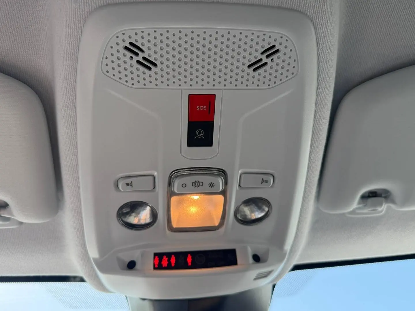 Plafonnier intérieur avec commandes d’éclairage et bouton SOS dans une Peugeot 208 gris Artense, vue de dessous.